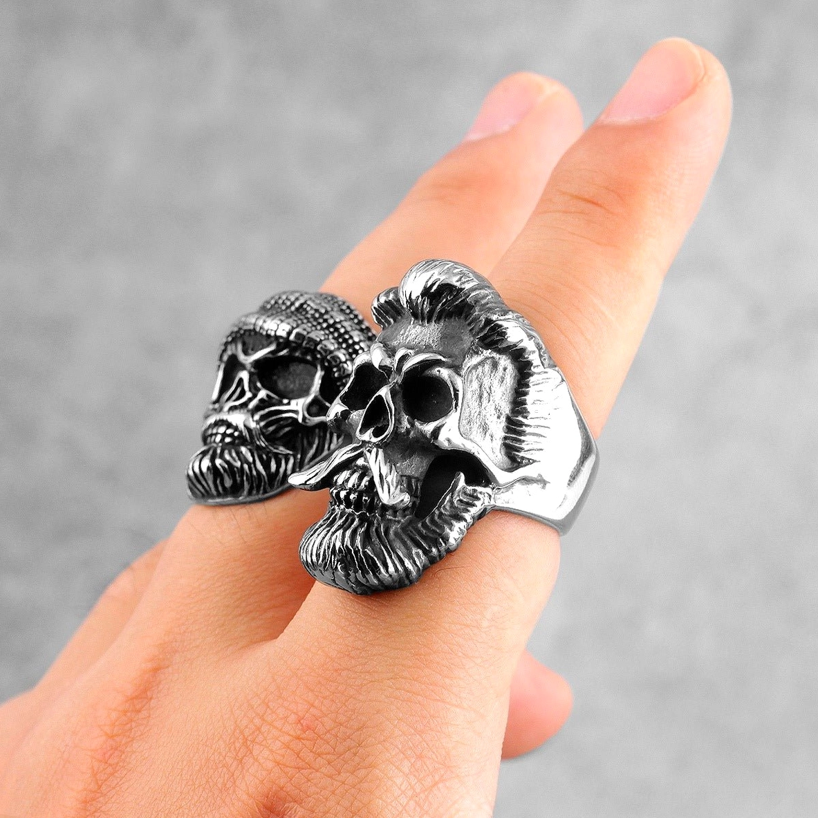 Two linked bearded skull gothic rings worn on fingers matching vintage silver design dark aesthetic