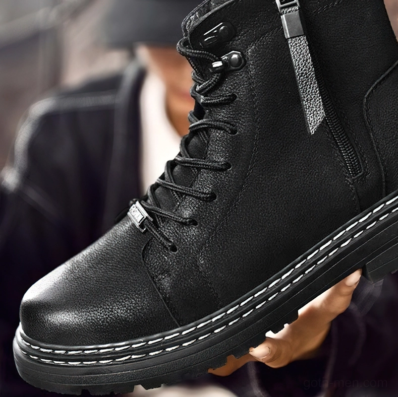 Close-up of black boot's side zipper, lace closure, and leather craftsmanship details