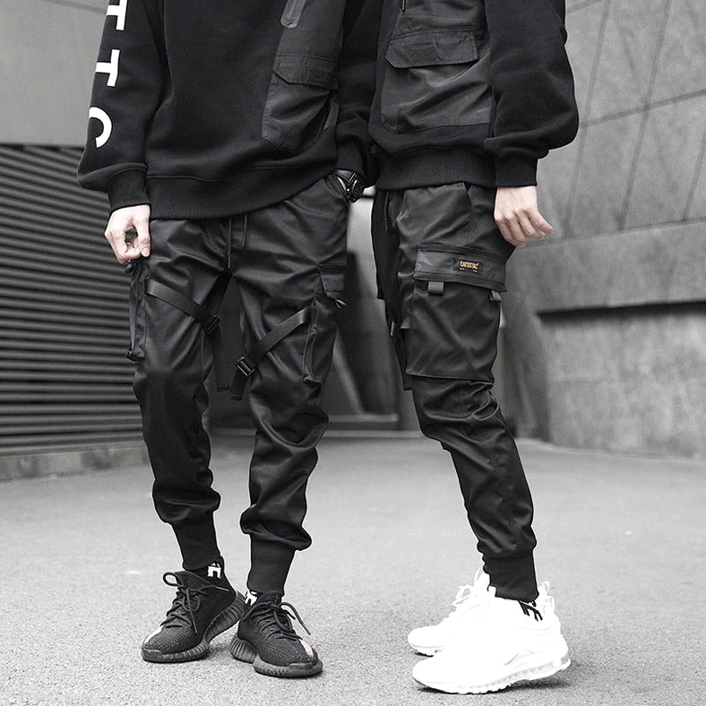 Black cargo pants with utility pockets and ribbon details - full body side view on model