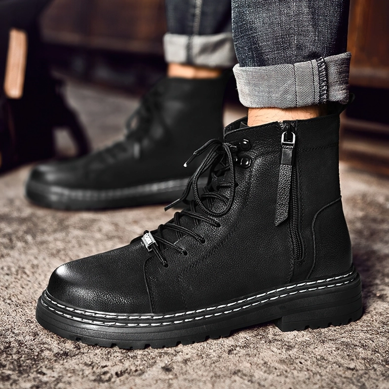 Three-quarter view of black leather combat boots with reinforced stitching and metal eyelets