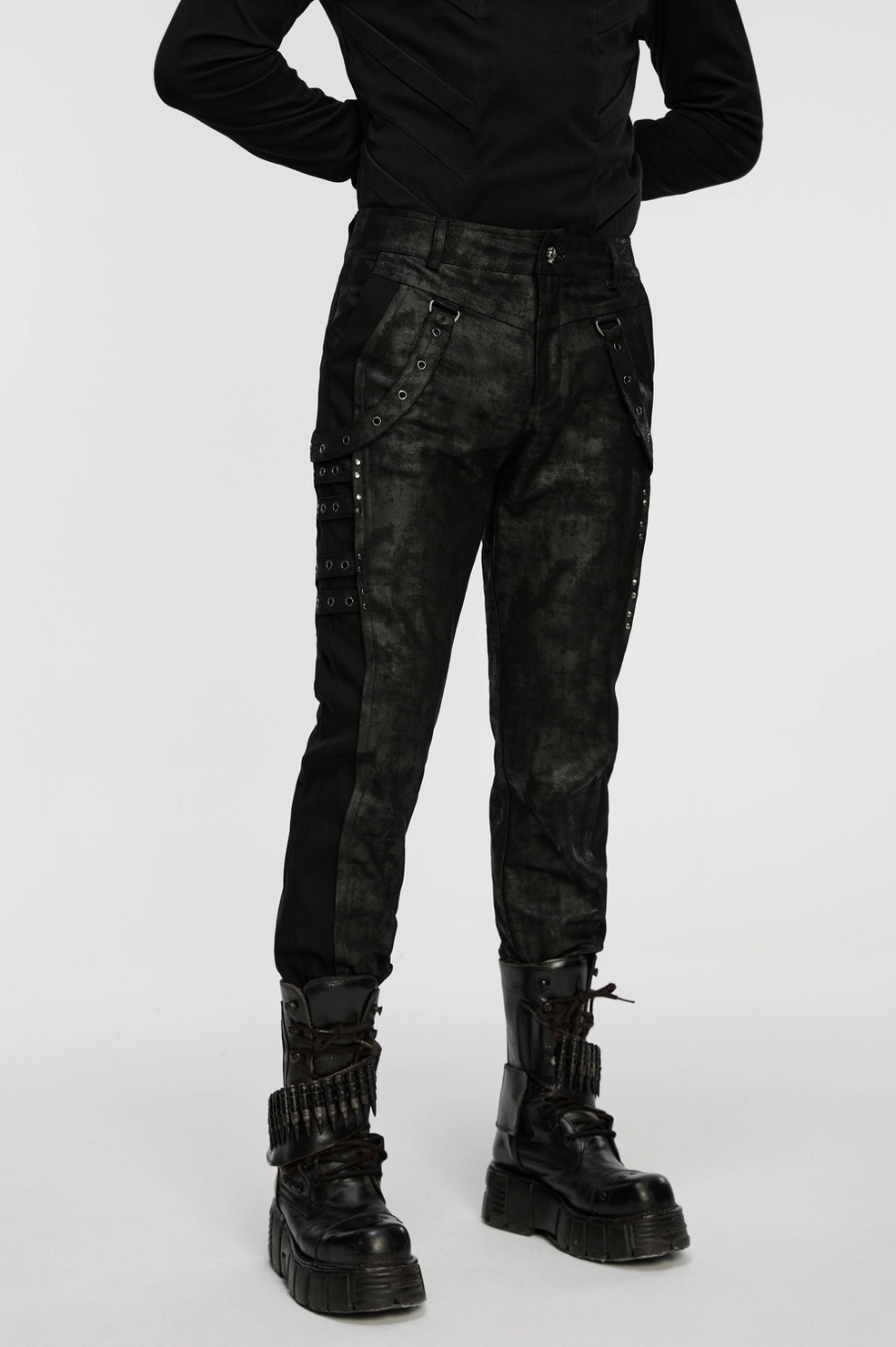 Black distressed gothic slim pants showing layered eyelet hardware and industrial metal accents