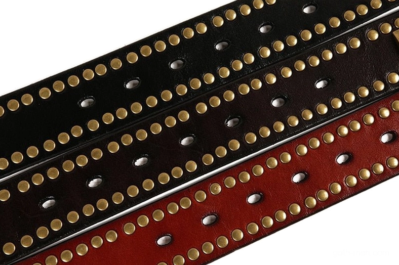 Black geometric rivet gothic belt buckle detail with bronze studs arrangement
