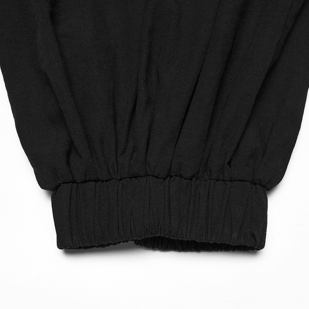Close-up side view of black gothic tapered pants ankle cuff, featuring gathered elastic hem and refined finishing detail