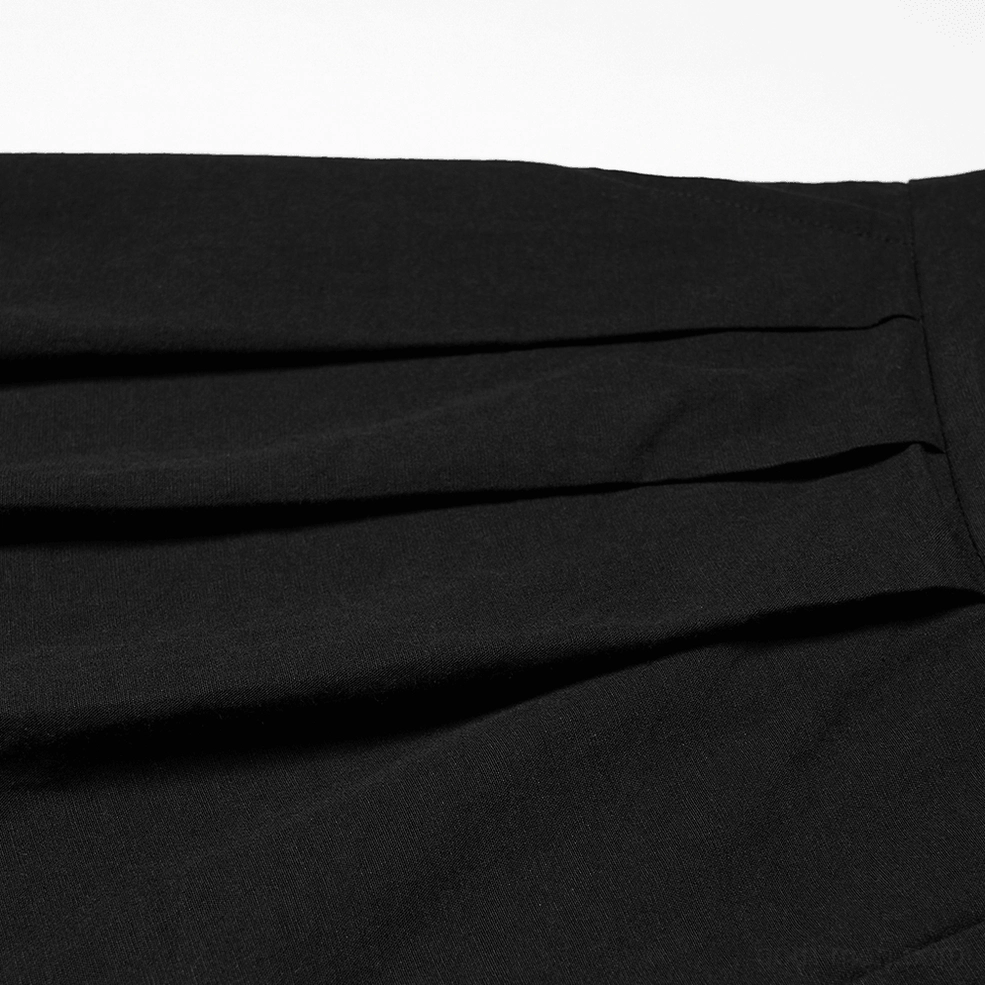 Close-up flat lay of black gothic pants fabric, showcasing matte solid weave and subtle crease detail of material quality