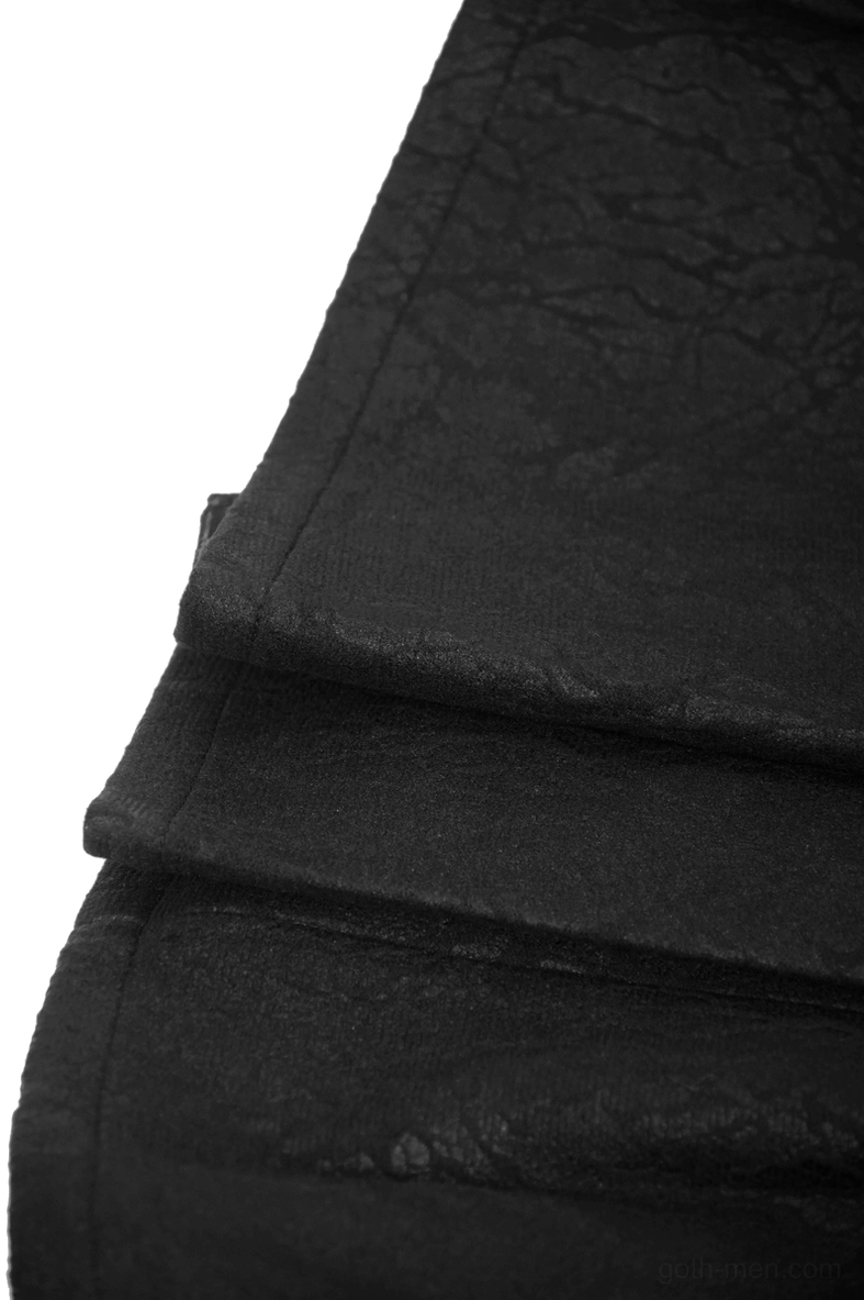 Macro detail shot of synthetic leather crinkle texture and pleated fabric folds on black gothic kilt