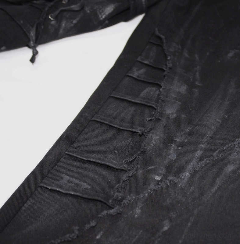 Front angled view of black gothic slim-fit pants featuring lace-up right leg and paint texture