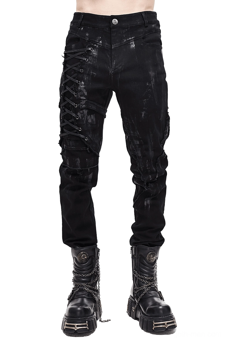 Black gothic slim-fit pants with lace-up detail on right leg, front view on male model wearing distressed trousers