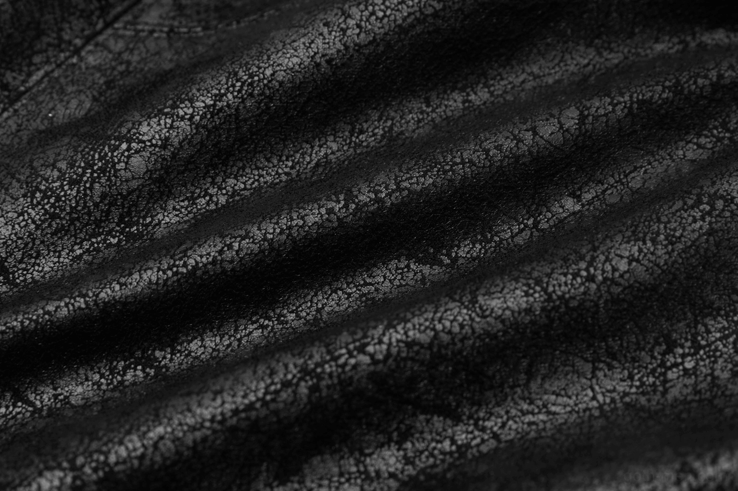 Cracked distressed black leather texture close-up flat lay showing aged finish