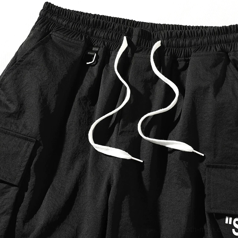Close-up detail of black cargo shorts waist drawstring and elastic band construction