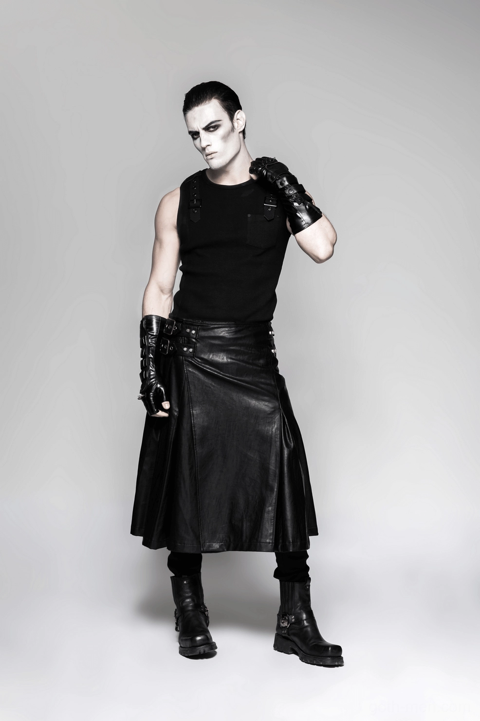 Three-quarter front pose of male model displaying black spiked gauntlet gloves with hand on shoulder
