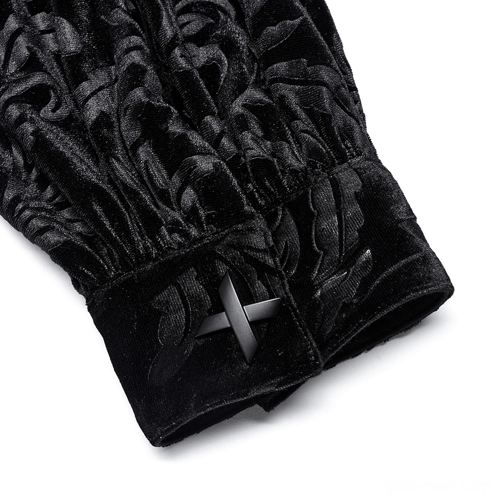 Close-up top-down detail of black velvet gothic shirt cuff with cross-shaped decorative button and embossed velvet texture