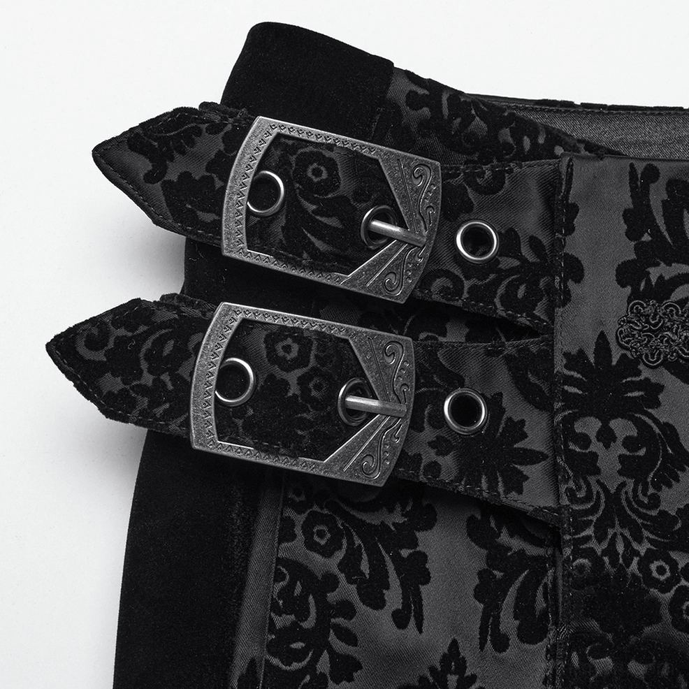 Close-up detail of black velvet gothic pants waist buckle showing vintage metal gemstone hardware and craftsmanship
