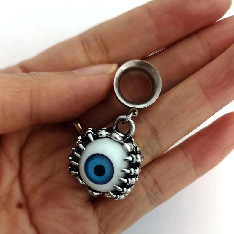 Single blue eye tunnel held in hand, showing intricate spiky frame design and silver finish from top-down angle