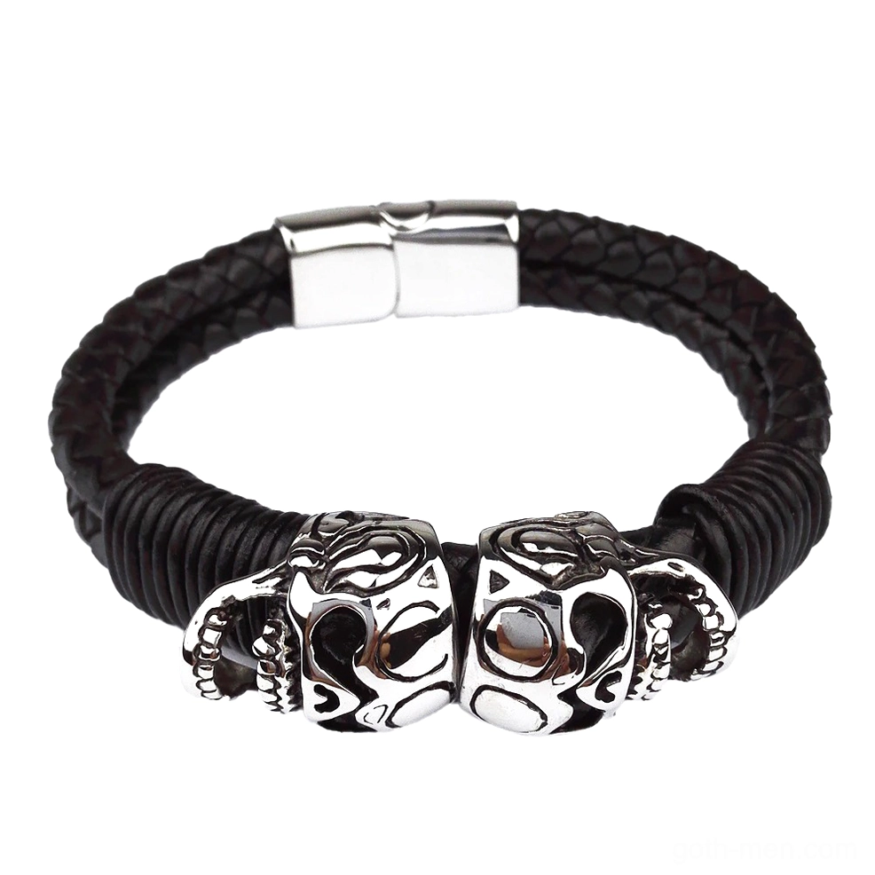 Double skull stainless steel charms on braided black leather bracelet, studio product photography