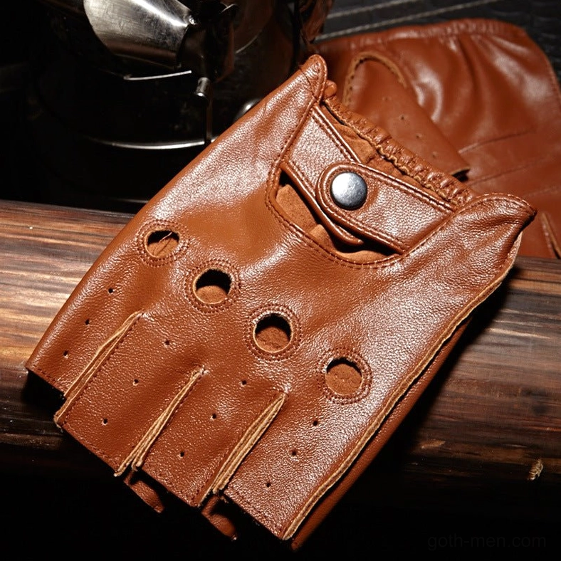 Brown sheepskin leather half-finger glove close-up showing circular perforations and snap button closure on wooden background