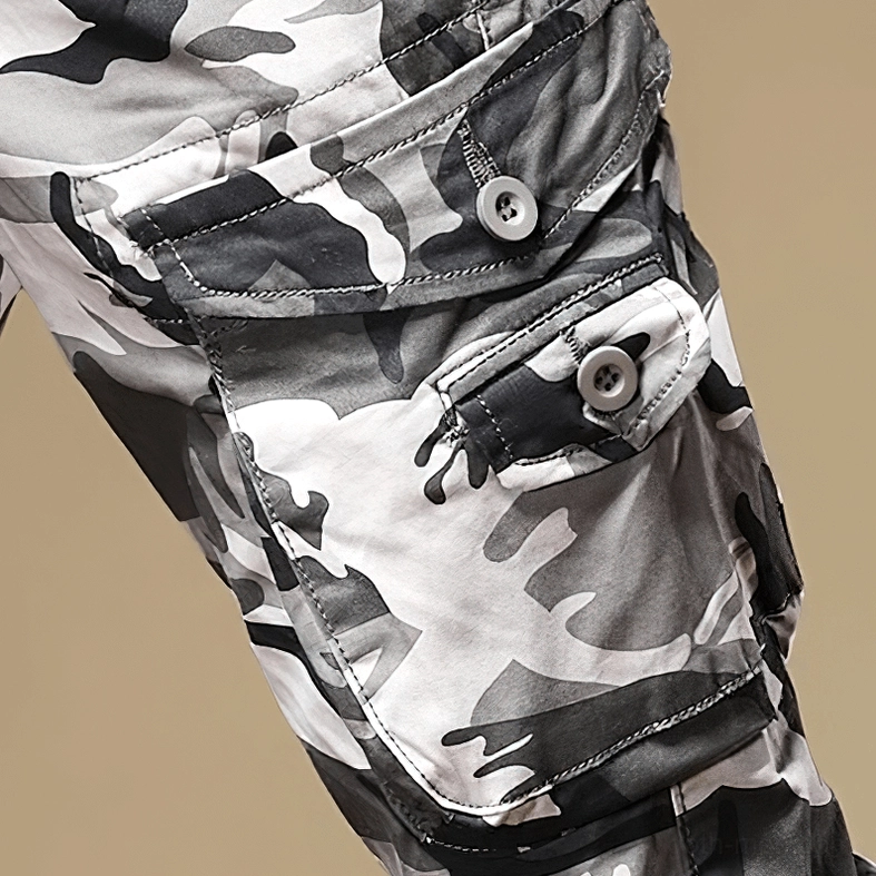 Camouflage cargo pants front waist detail showing button fly, belt loops, and fabric texture on male model