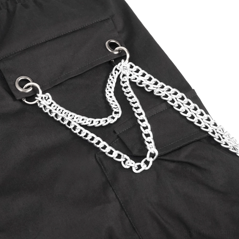 Detailed view of black cargo pants showcasing metal buttons, rivets, and industrial gothic design elements