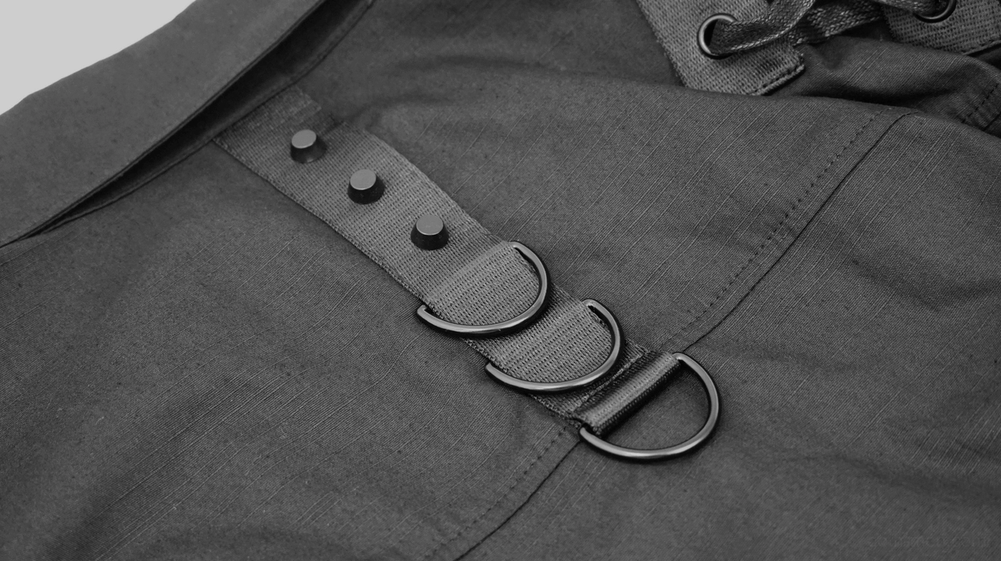 Cyberpunk tactical shirt collar hardware detail showing D-rings and adjustment straps