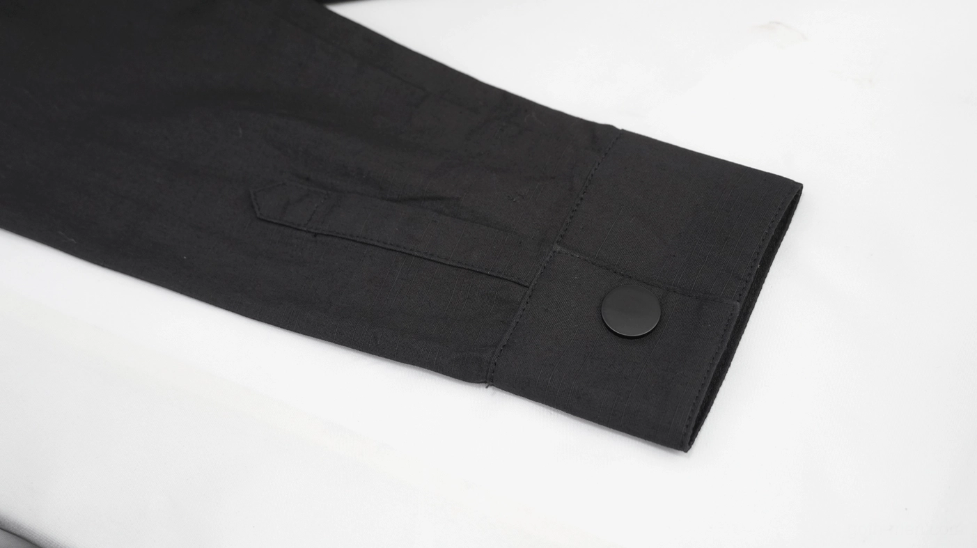 Cyberpunk shirt cuff detail showing buttoned closure on black woven fabric