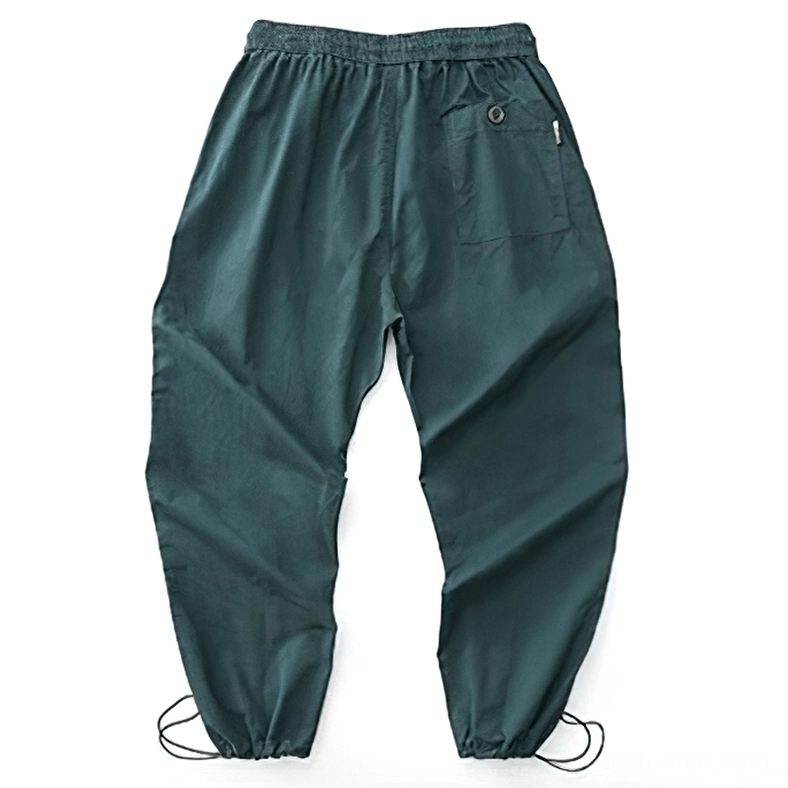 Dark green gothic casual harem pants full front view flat lay emphasizing elastic waist and drawstring ankle cuffs construction