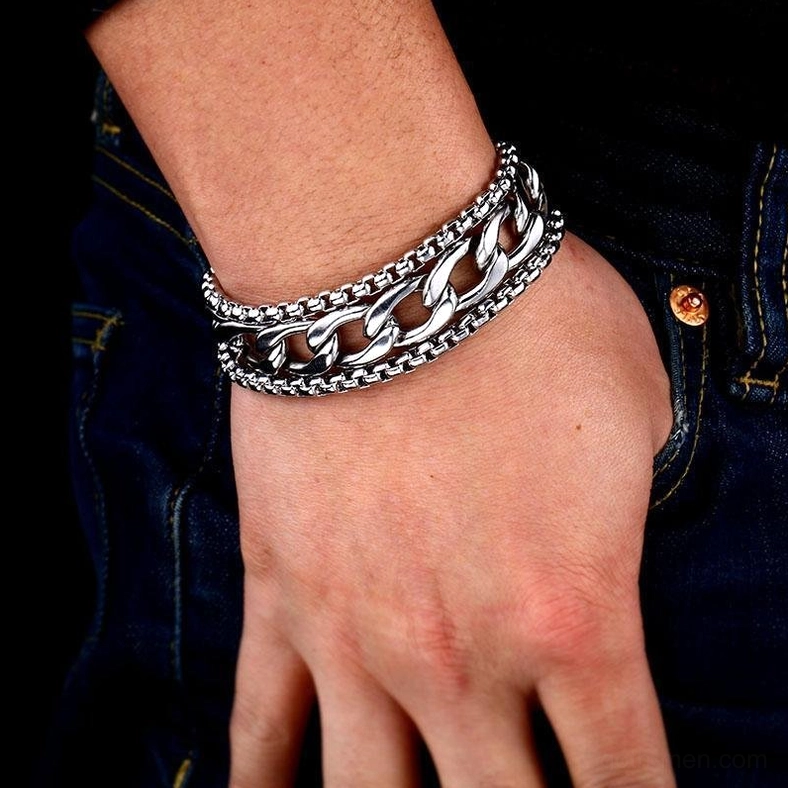 Double-chain stainless steel bracelet front wrist close-up on male hand wearing denim, tight fitting layered chain gothic jewelry design silver