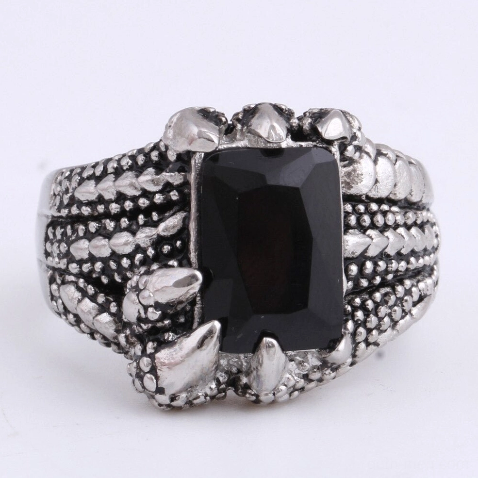 Close-up detail of dragon claw ring showing four metal prongs gripping black onyx stone, scaled texture band