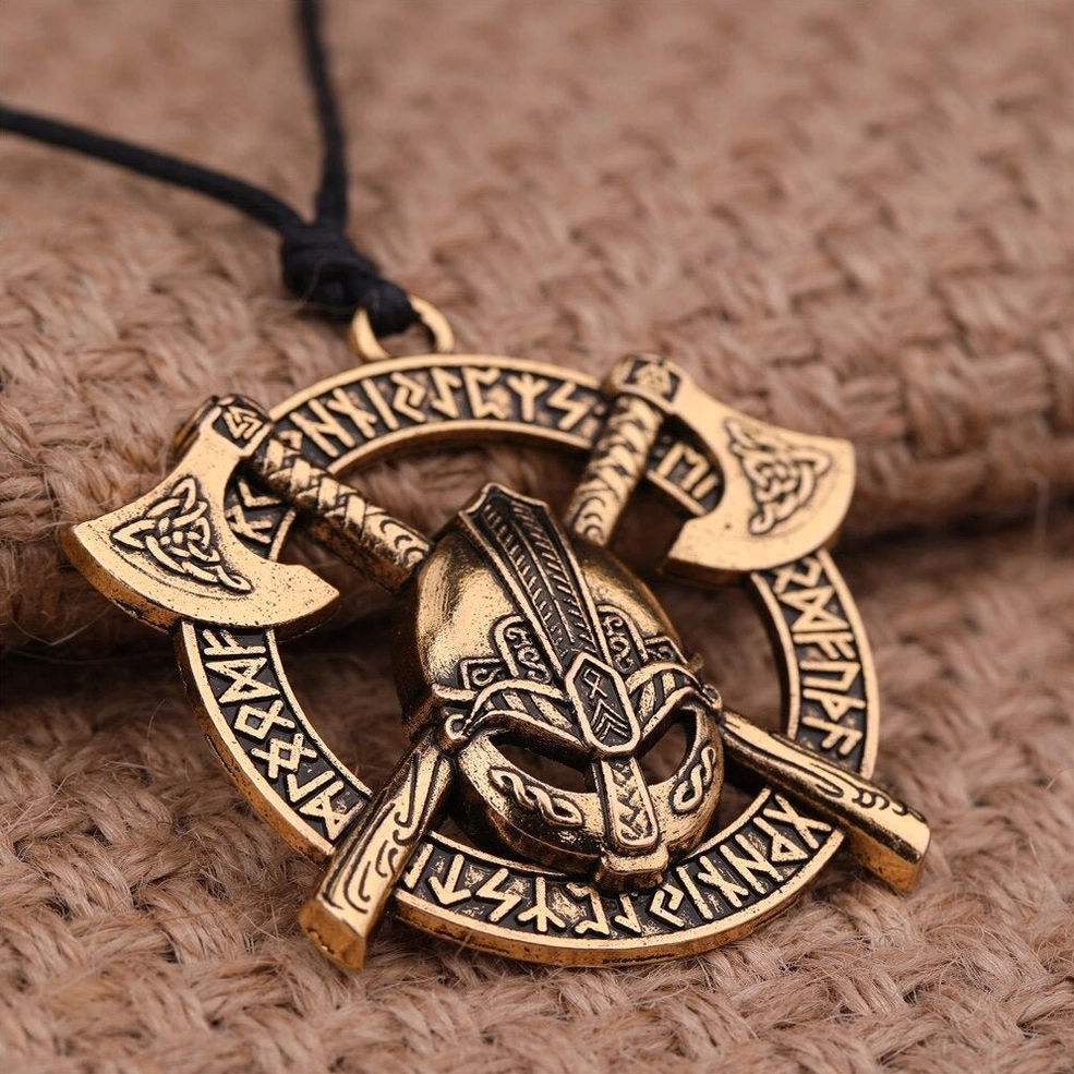 Gold gothic warrior pendant necklace with crossed axes and rune symbols overhead view