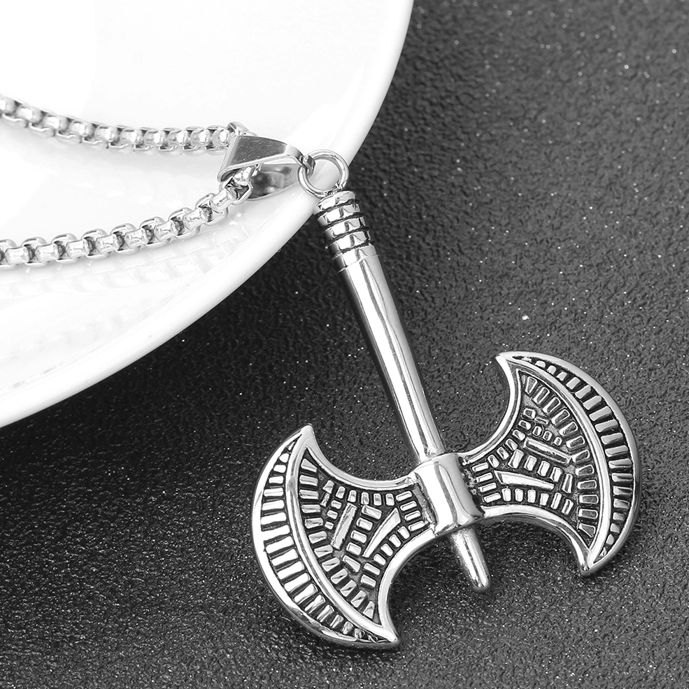 Gothic necklace pendant placed beside white ceramic plate dark moody background