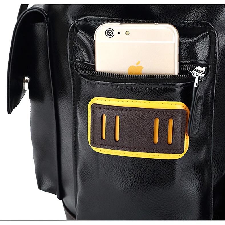 Backpack front pocket detail showing zippered phone slot, yellow-brown decorative patch, and fastening mechanism