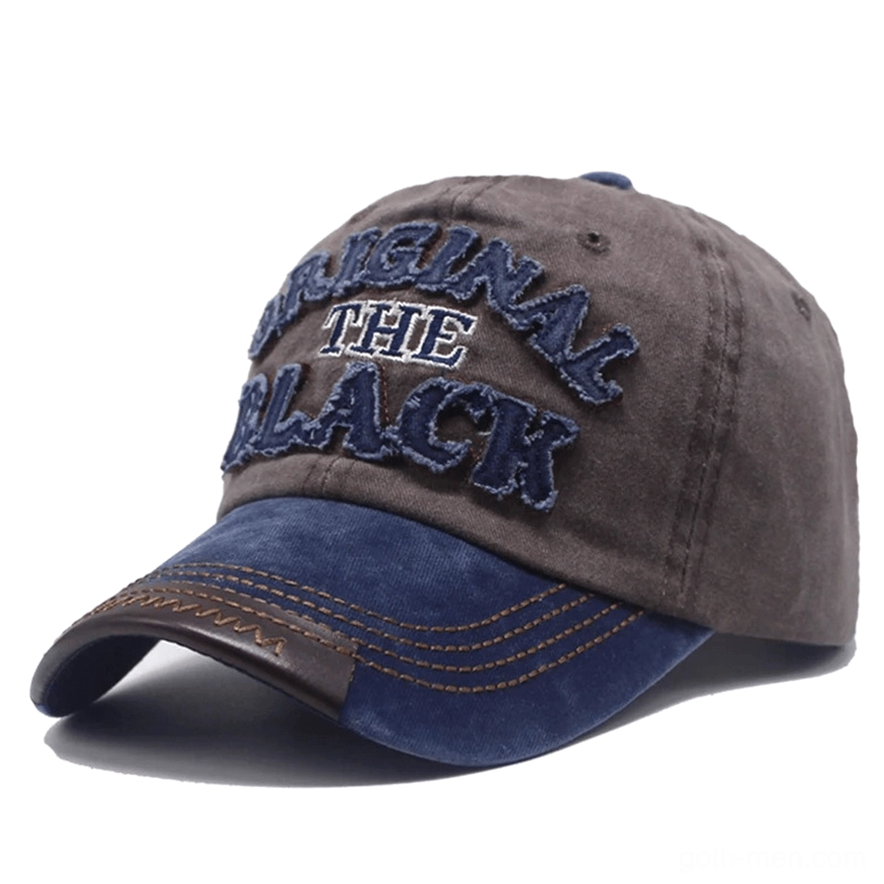Washed gothic baseball cap detail shot showing embroidered letter logo craftsmanship and fabric texture