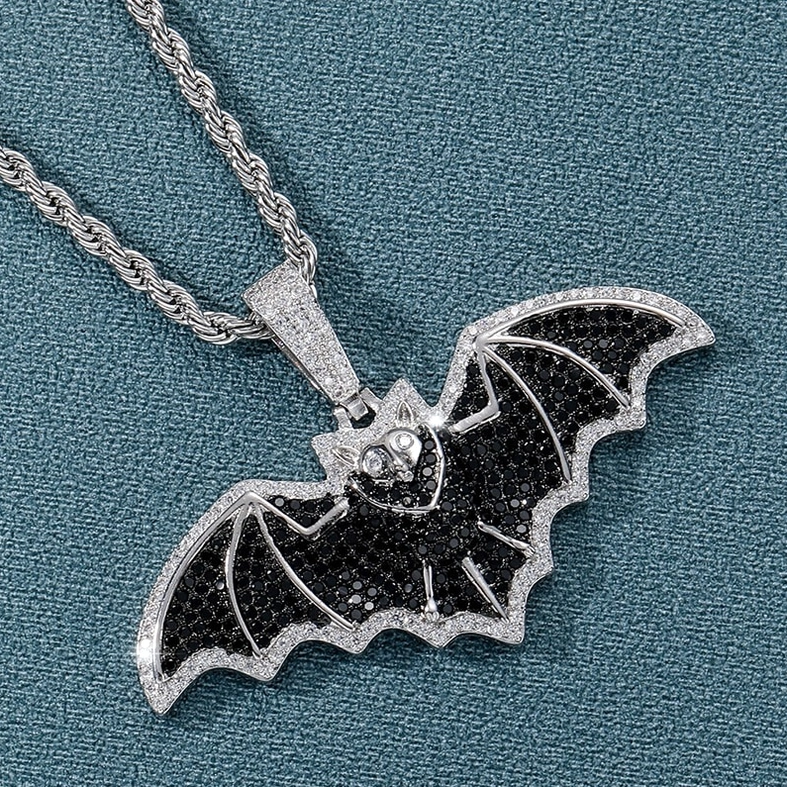 Gothic bat silver necklace pendant at 3/4 angle on twist chain with black pavé cubic zirconia wing details and teal background