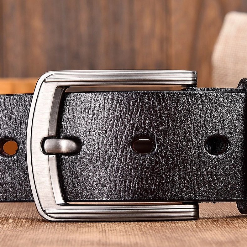 Gothic leather belt buckle detail with punched holes and brushed silver metal finish