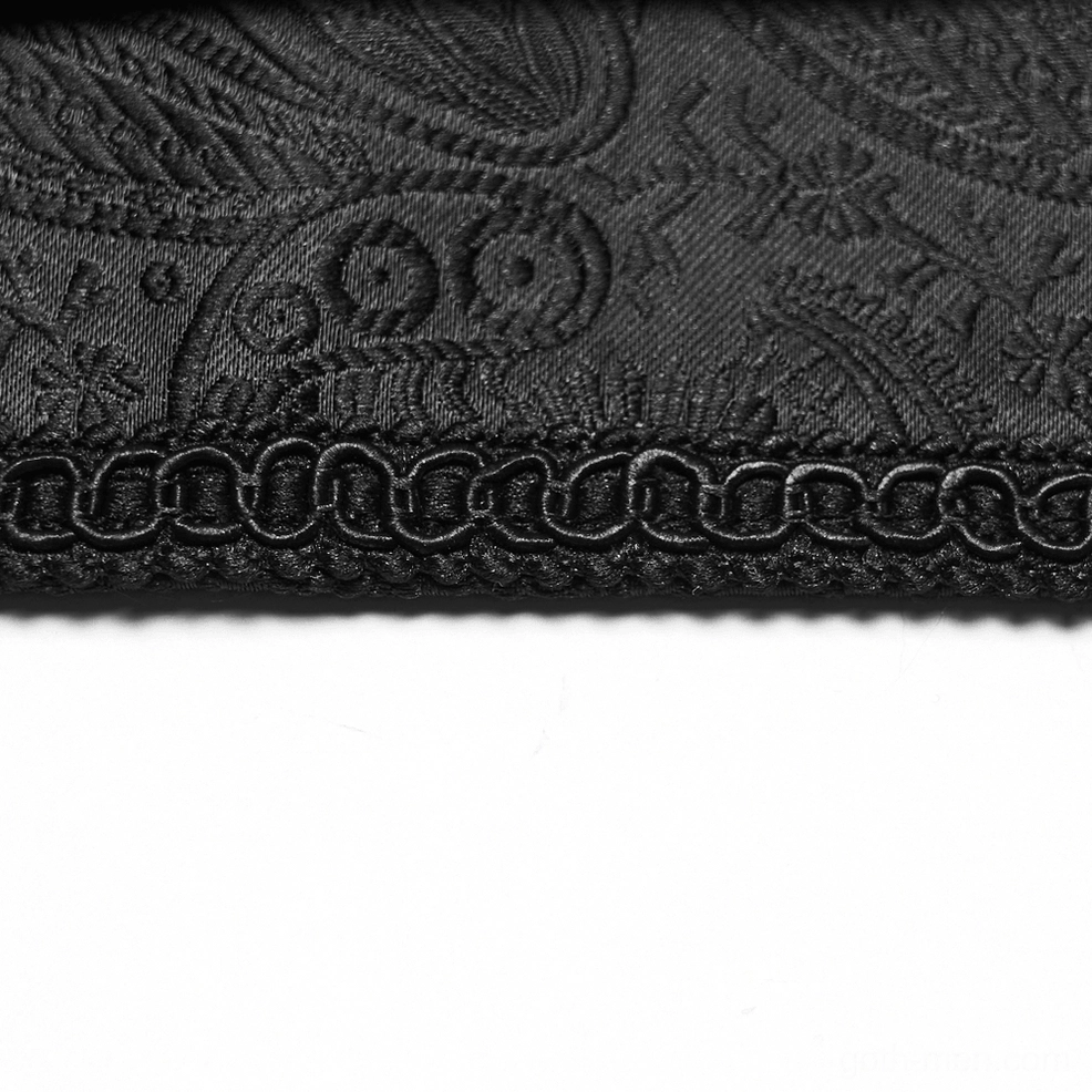 Bottom edge close-up of black jacquard gothic belt showing chain-stitched trim detail and paisley fabric weave construction