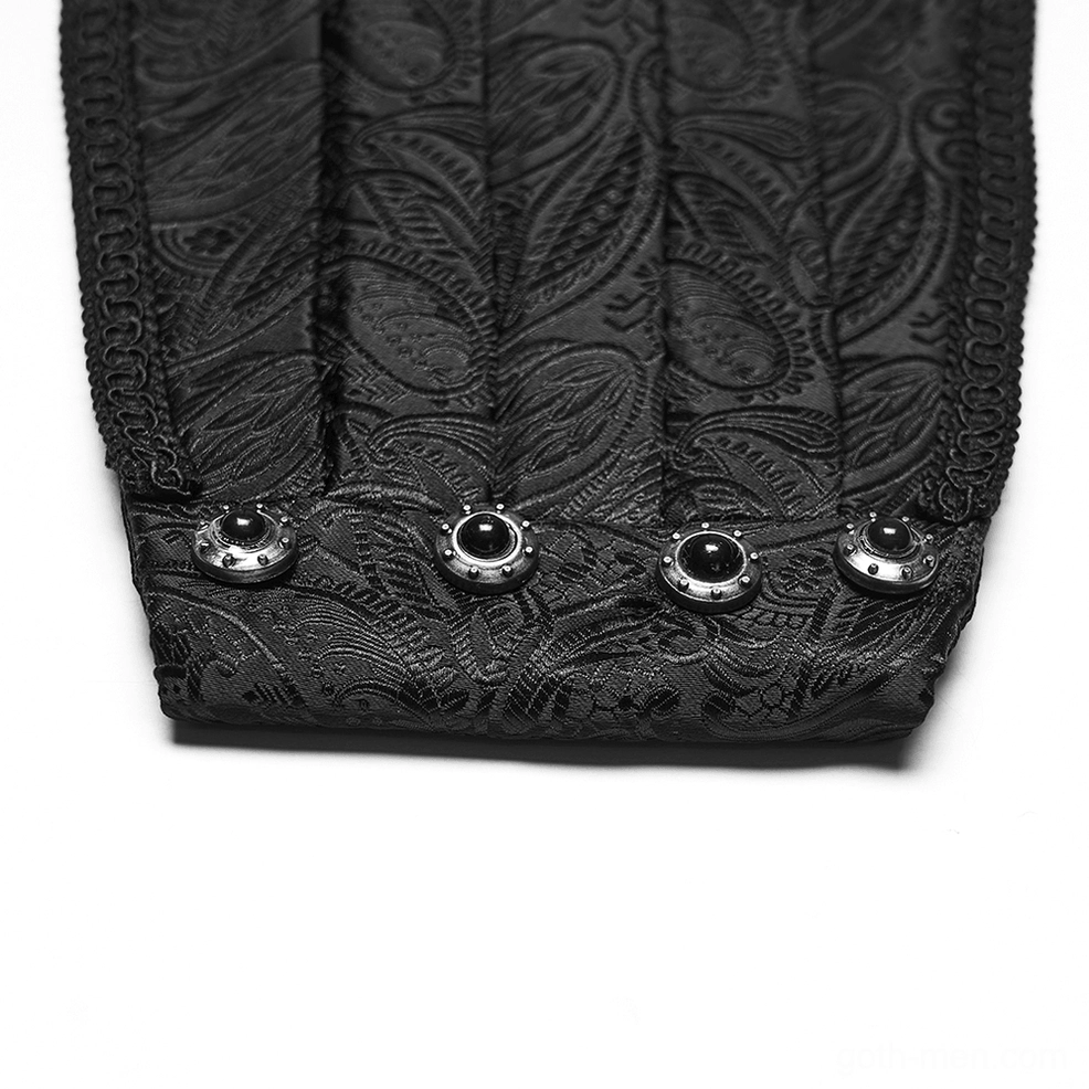 Edge close-up of black gothic jacquard belt featuring decorative blackened metal snap buttons and stitched trim on paisley fabric