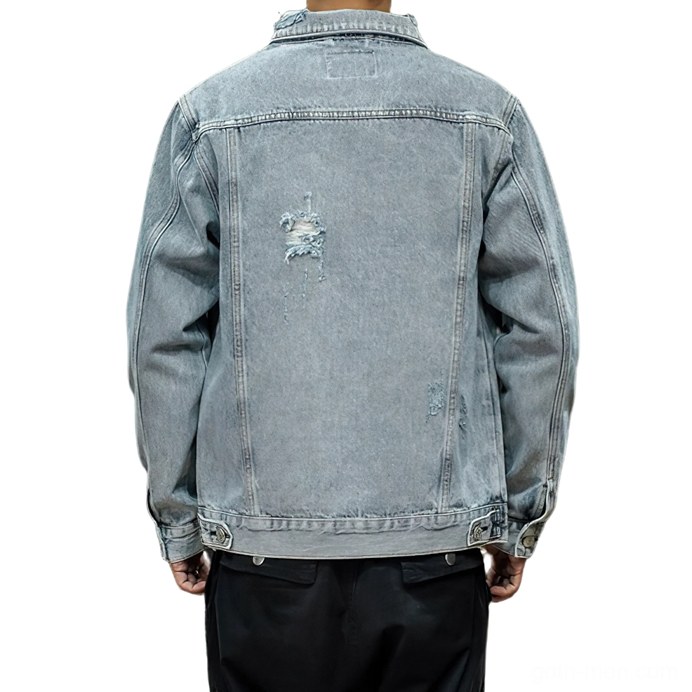 Back view of blue denim gothic jacket on model displaying strategic distressed rips, hem adjustment buttons, and industrial detailing