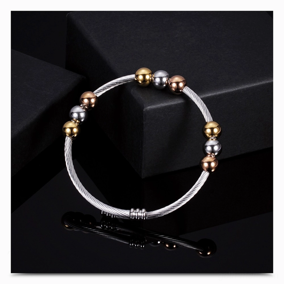 Gold and silver two-tone gothic cuff bracelet on reflective black display surface