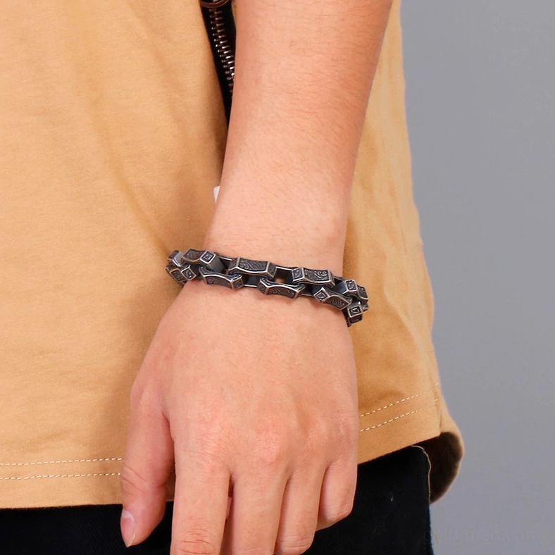 Dark silver gothic bracelet worn on male wrist side close-up view