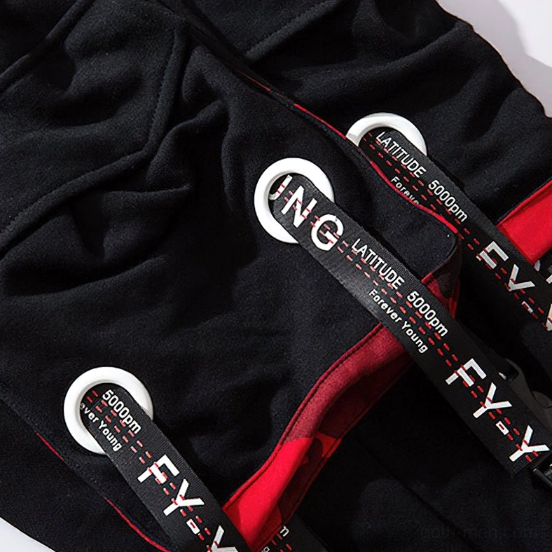 Detailed view of black gothic cargo joggers cargo pocket with metal eyelet decoration and lettered strap accents