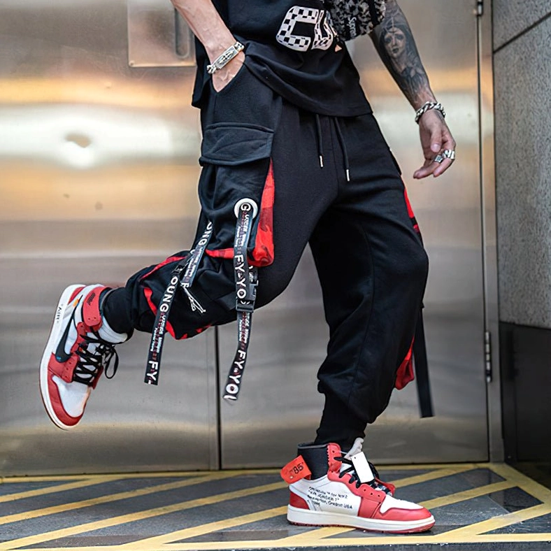 Black gothic cargo joggers side pocket and strap system close-up showing functional and decorative elements
