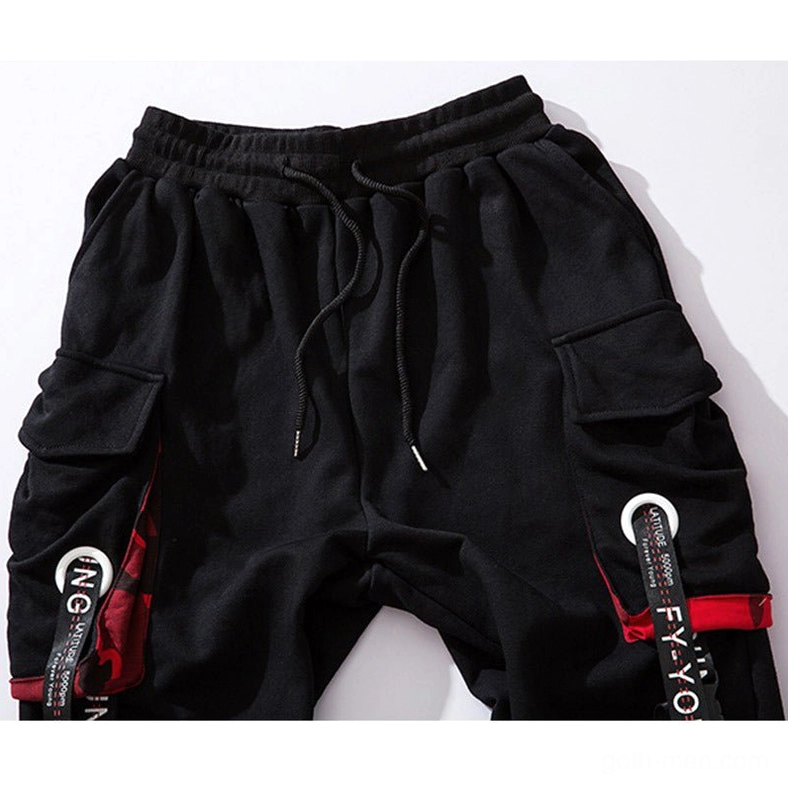Close-up of black gothic cargo joggers waistband and cargo pocket featuring drawstring, dual pockets, and decorative strap elements