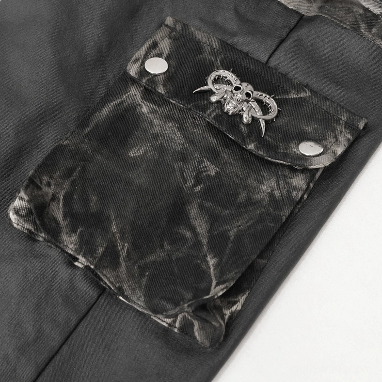 Close-up detail of black gothic cargo joggers showing skull metal emblem and snap fasteners