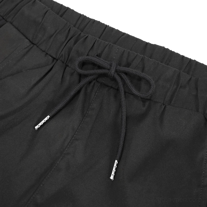 Front waistband detail of gothic cargo pants showing elasticated drawstring waist with metal-tipped drawcord