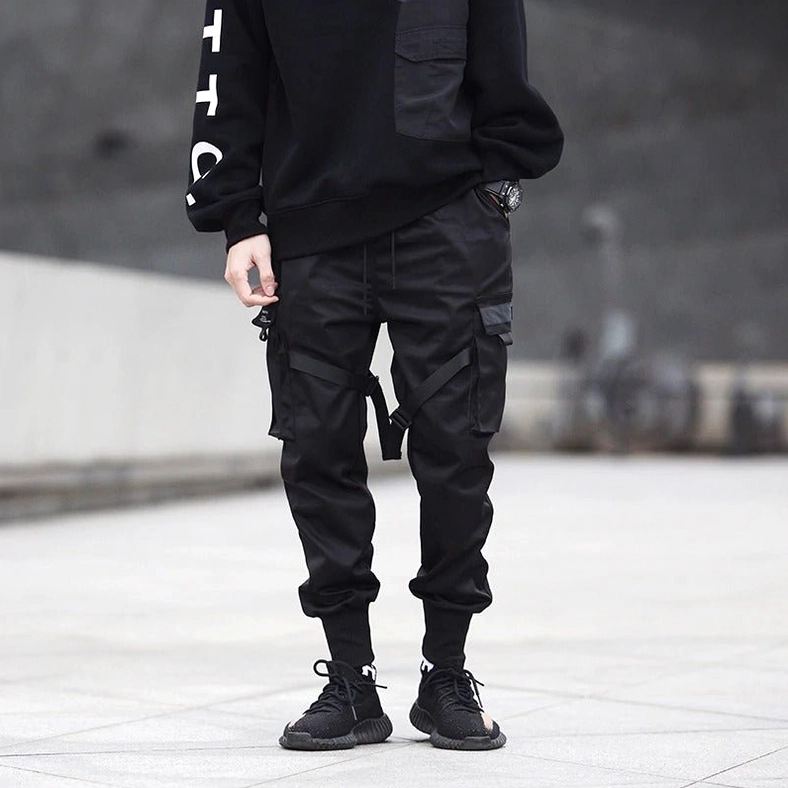 Male model in black gothic cargo pants with multiple pockets - front three quarter view