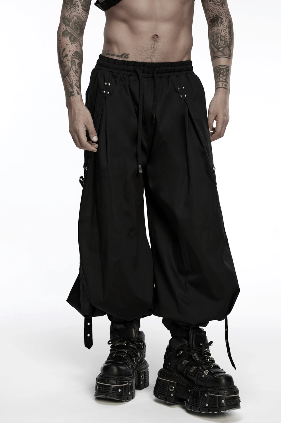Black gothic cargo pants layered look demonstrating loose fit and dramatic draping silhouette