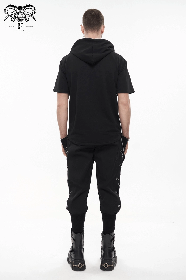 Metal chain eyelet trim running down leg of black gothic cargo pants with close-up focus