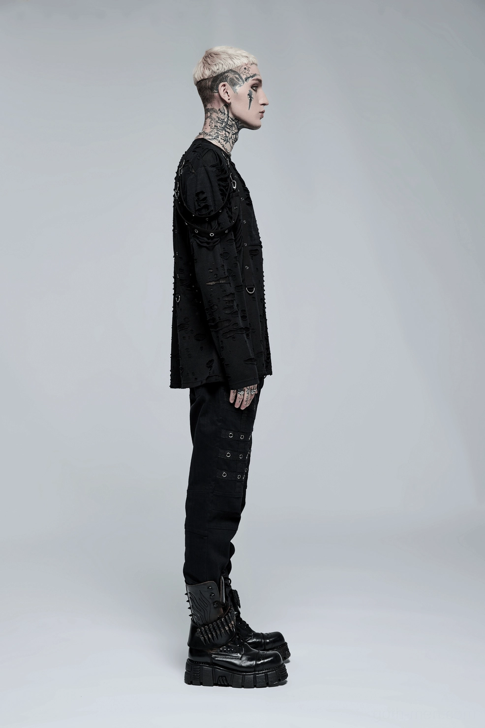 Walking pose of male model wearing black gothic cargo pants demonstrating comfort fit and movement flexibility