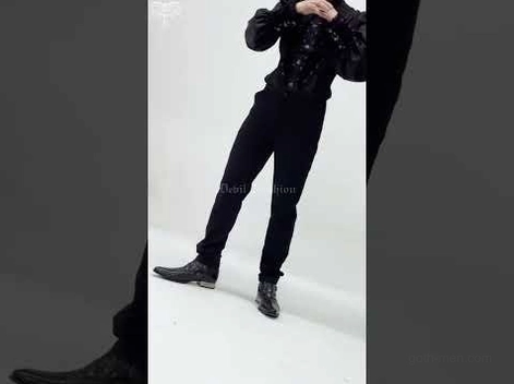 Male model wearing black gothic lace cargo pants with platform boots dynamic posture