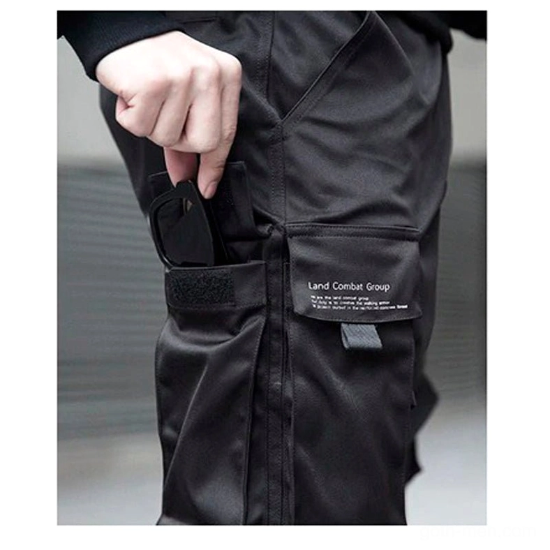 Close-up of gothic cargo pants pocket with velcro strap and brand patch detail