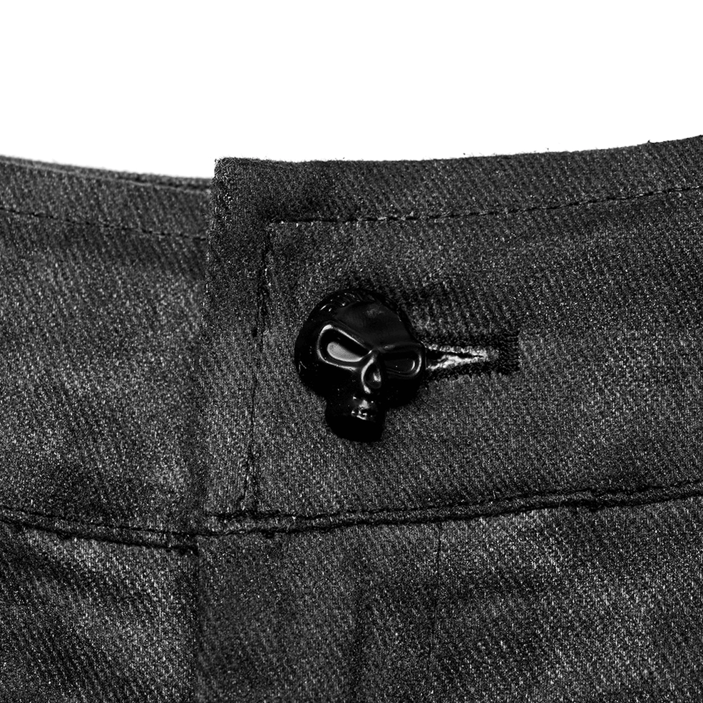 Close-up detail of skull-shaped button closure on gothic cargo pants with micro-elastic distressed coated denim fabric