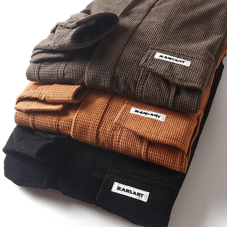 Stacked oversized gothic cargo shirts in multiple color variations with close-up detail of waffle cord texture and brand pocket tags for alternative menswear